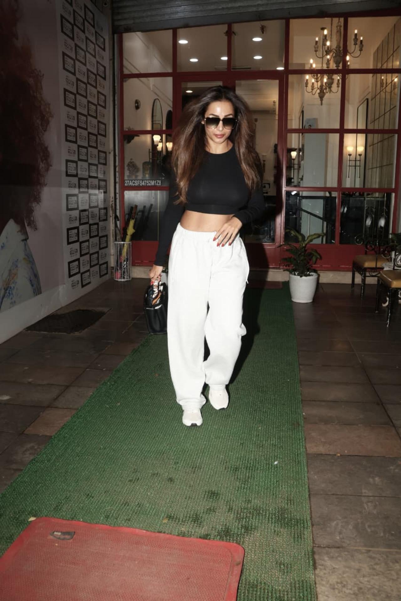 Malaika Arora stepped out for a salon session in the city, as she was papped leaving a salon in a black crop-top and white pants.